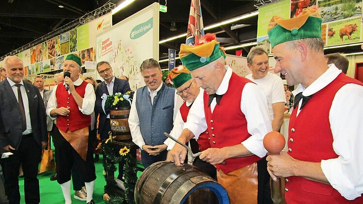 Die Kulmbacher Büttner zapfen bei der Preisverleihung in der Consumenta einen "Eisbock" an. Dahinter die beiden Landräte von Kulmbach und Bayreuth, Klaus Peter Söllner und Hermann Hübner. Foto: Privat