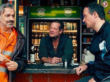 Die alten Schulfreunde  Guido (Alexander Wipprecht, links), Hajo (Aurel Manthei, Mitte) und Thorsten (Johannes Allmayer) leben und philosophieren &uuml;ber weite Strecken des Tages an Hajos Kiosk. Bis ein Koffer ihr Leben ver&auml;ndern k&ouml;nnte.