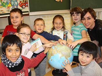 Zeigefinger aufs Heimatland: Migrationsbeauftragte Marietta Menz (rechts) unterrichtet in ihrem Förderkurs für die zweite Klasse der Sinnberg-Schule (von links vorne im Uhrzeigersinn) Luis aus Spanien, Malgoscha und Dominik aus Polen, Ricards, Veronika und Tatiana aus Russland sowie Hieu aus Vietnam. Foto: Ralf Ruppert