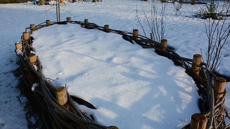 Unter der Schneedecke schlummert das im Herbst vorbereitete Hochbeet.