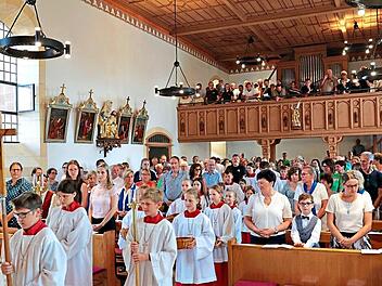 Die Ministranten und Geistliche ziehen in die gut besuchte Pfarrkirche in Schnaid_ein. Mathias Erlwein