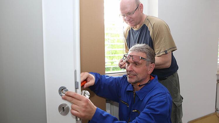 Thomas Schmidt (rechts) passt auf, dass sein Ein-Tages-Azubi Friedwald Schedel den Türdrücker richtig einbaut. Foto: Matthias Hoch