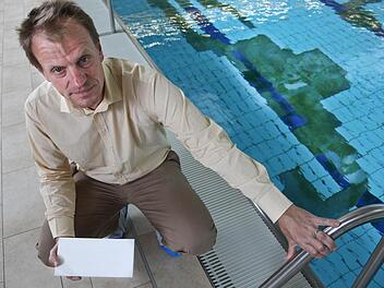 Die weiße Fliese in der Hand statt am Beckenboden: Im Wasser neben Christoph Jeromin ist der Schaden deutlich zu sehen. Foto: Matthias Hoch