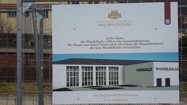 Eine Schautafel am Bauzaun informiert die Passanten darüber, wie die Wandelhalle im Staatsbad nach der Generalsanierung von außen aussehen wird. Foto: Rolf Pralle