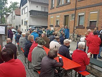 Die frühere Ortsmitte an der Hauptstraße in Oerlenbach erlebte neues Leben, als mit Musik und Festbetrieb ein Gedenkstein eingeweiht wurde. Bürgermeister Franz Kuhn (hinten Mitte) erinnerte an die Geschichte des Platzes und dankte den Jagdgenossen, die den Stein spendierten.