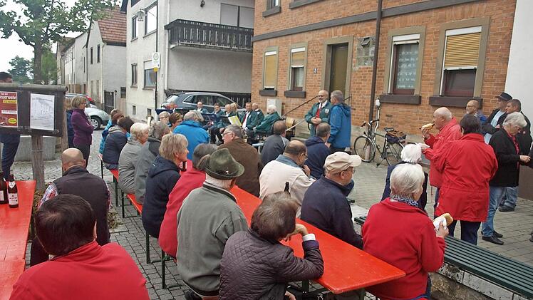 Die frühere Ortsmitte an der Hauptstraße in Oerlenbach erlebte neues Leben, als mit Musik und Festbetrieb ein Gedenkstein eingeweiht wurde. Bürgermeister Franz Kuhn (hinten Mitte) erinnerte an die Geschichte des Platzes und dankte den Jagdgenossen, die den Stein spendierten.