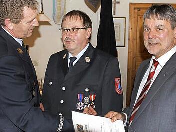Stellvertretender Landrat Gerhard Wunder (rechts) und Kreisbrandinspektor Harald Schnappauf (links) zeichneten den Ehrenkommandanten Olaf Imsel für 40 Jahre Dienstzeit aus.  Fotos: Michael Wunder