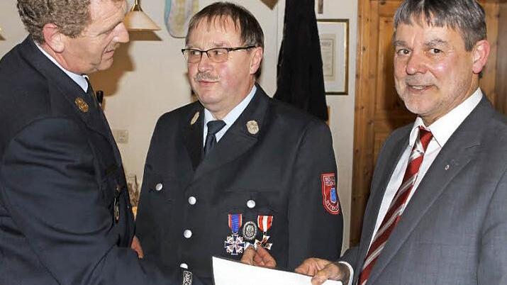 Stellvertretender Landrat Gerhard Wunder (rechts) und Kreisbrandinspektor Harald Schnappauf (links) zeichneten den Ehrenkommandanten Olaf Imsel für 40 Jahre Dienstzeit aus.  Fotos: Michael Wunder