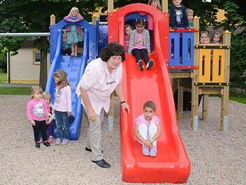 Freude herrscht bei den Kindern auf dem Multifunktionsgerät mit Schaukel, Rutsche und Klettermöglichkeit. Lee Ann Williams hat gerade ihre erste Rutschpartie hinter sich gebracht. Kindergartenleiterin Margaretha Gwosdek muss bei so viel Andrang gut aufpassen. Foto: Hofmann