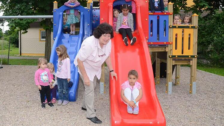 Freude herrscht bei den Kindern auf dem Multifunktionsgerät mit Schaukel, Rutsche und Klettermöglichkeit. Lee Ann Williams hat gerade ihre erste Rutschpartie hinter sich gebracht. Kindergartenleiterin Margaretha Gwosdek muss bei so viel Andrang gut aufpassen. Foto: Hofmann