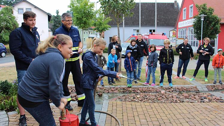 Künftige Feuerwehrfrauen üben sich im Zielspritzen. Floyd und Jürgen Frerichs von der Schlüsselfelder Feuerwehr werden messen.