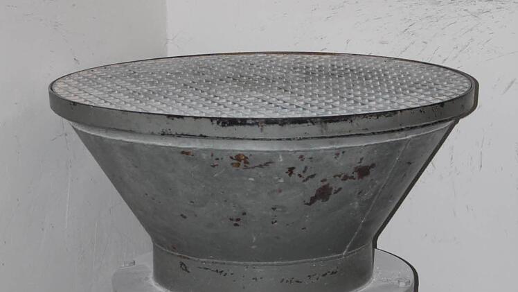 Das Material, das den pH-Wert des Wasser korrigiert, wird von Hand in diesen Trichter geschüttet. Foto: Ulrike Müller