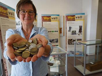 Birgit Speckle, beim Bezirk Unterfranken für Heimatpflege zuständig, nimmt eine Handvoll Brotmarken. Foto: Arkadius Guzy