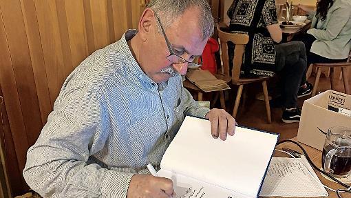 Autor G&uuml;nter B&ouml;hner schrieb pers&ouml;nliche Widmungen in die B&uuml;cher, die er am Vortragsabend verkaufte.