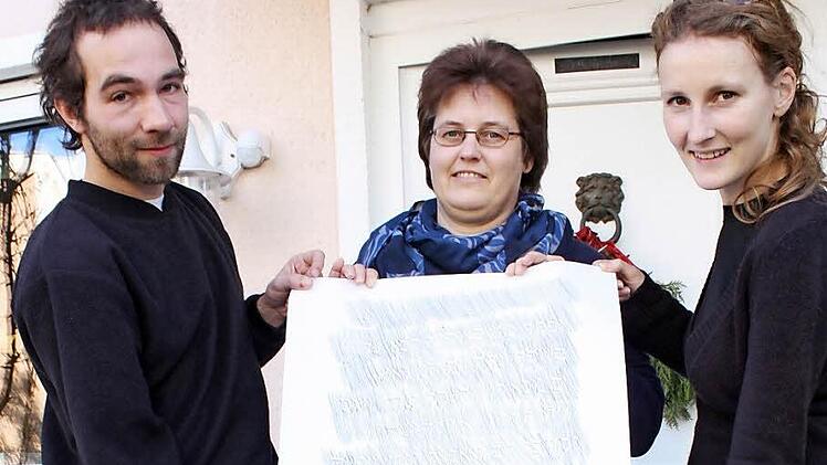Krzysztof Gutkowski, Claudia Nieland (Mitte) und Ida Zagrzejewska mit dem abgepausten Grabstein des Ururgroßvaters.  Foto: Robert Huger
