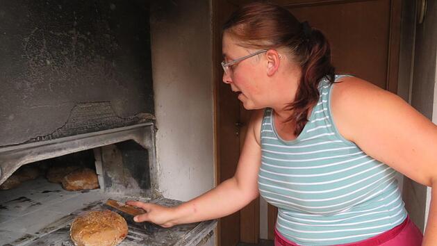 Nach einer Stunde Backzeit im Holzofen sind die Bauernbrote von Irene Grasser (Loffeld) fertig. Die Vorbereitung des Teigs beginnt schon zwei Tage vorher. Fotos: Monika Sch&uuml;tz