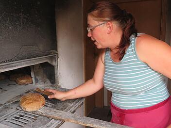 Nach einer Stunde Backzeit im Holzofen sind die Bauernbrote von Irene Grasser (Loffeld) fertig. Die Vorbereitung des Teigs beginnt schon zwei Tage vorher. Fotos: Monika Schütz