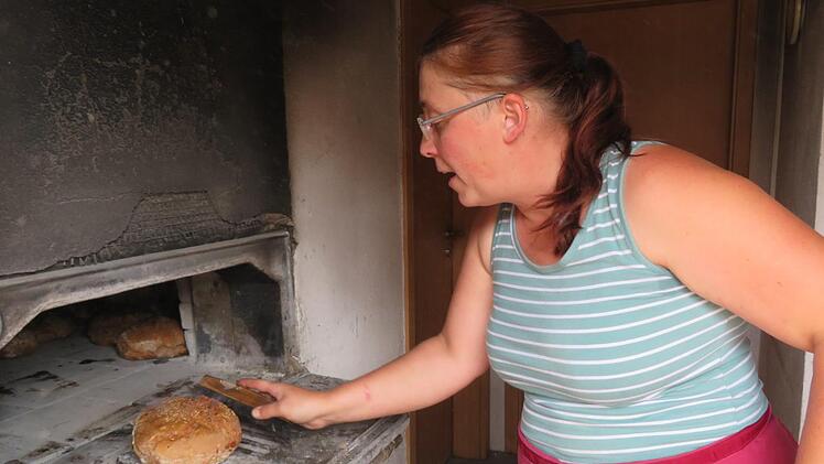 Nach einer Stunde Backzeit im Holzofen sind die Bauernbrote von Irene Grasser (Loffeld) fertig. Die Vorbereitung des Teigs beginnt schon zwei Tage vorher. Fotos: Monika Schütz