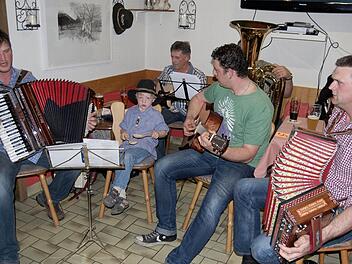 Frank Schmitt (links) und seine Freunde begleiteten die 120 Sänger mit Akkordeon, Gitarre, Tuba und Holzlöffeln. Tatkräfig unterstützt wurden die Musiker von dem vierjährigen Nils, dem Sohn von Frank Schmitt.Fotos: Sigismund von Dobschütz