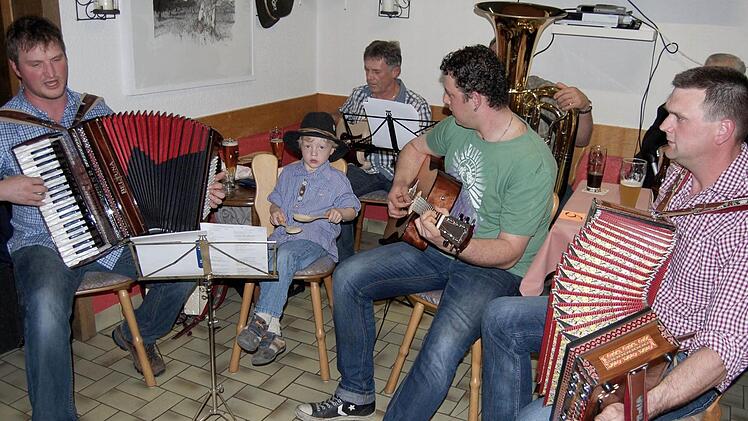 Frank Schmitt (links) und seine Freunde begleiteten die 120 Sänger mit Akkordeon, Gitarre, Tuba und Holzlöffeln. Tatkräfig unterstützt wurden die Musiker von dem vierjährigen Nils, dem Sohn von Frank Schmitt.Fotos: Sigismund von Dobschütz