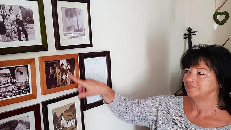 Gabi Aumüller vor der Familienwand im Gastzimmer. Früher war hier das Wohnzimmer der Familie Reitz/Aumüller.
