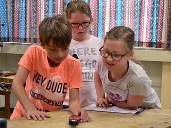Xaver misst die Temperatur im Werkraum der Lauterer Grundschule. Lilia und Sina sind erstaunt, wie dunkel es ist. Foto: Kathrin Kupka-Hahn