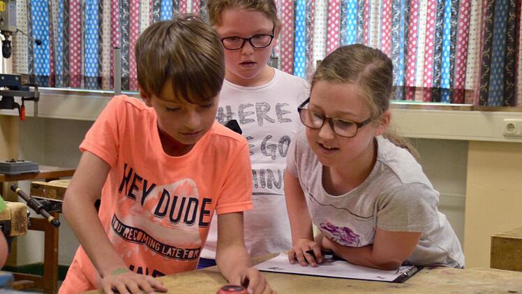 Xaver misst die Temperatur im Werkraum der Lauterer Grundschule. Lilia und Sina sind erstaunt, wie dunkel es ist. Foto: Kathrin Kupka-Hahn