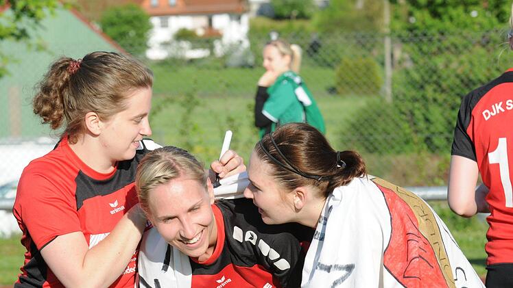Begehrte Unterschriften: Die Spielerinnen der DJK Schondra verewigen sich auf dem Meister-Banner.  Fotos: ssp