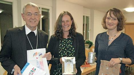 Voller Freude nahm Erzbischof Ludwig Schick die Dankesbilder der Kinder entgegen, um die sich Kerstin Ponsel und Tanja Völker (von links) bei ihrer Arbeit im Caritasverband kümmern.  Foto: Edwin Meißinger