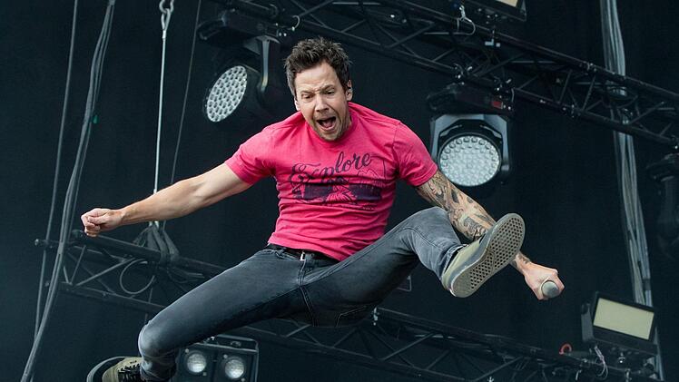 er Sänger der kanadischen Rockband Simple Plan, Pierre Bouvier, springt am 04.06.2017 in Nürnberg (Bayern) bei Rock im Park auf der Bühne. Foto: Daniel Karmann/dpa
