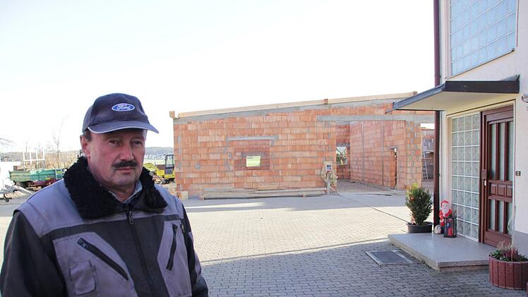 Wilfried Sauer  musste monatelang warten, ehe er mit dem Rohbau für seine neue Halle (im Hintergrund) beginnen konnte.  Foto: Andreas Dorsch