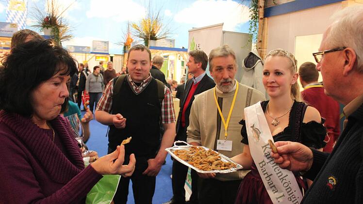 Karpfenkönigin Barbara Römer (rechts) und Teichgenossenschaftsvorsitzender Walter Jakob ließen auf der Grünen Woche in Berlin die Besucher Karpfenchips probieren. Foto: Andreas Dorsch