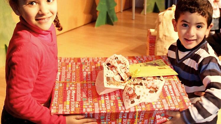 Glückliche Kinderaugen bei der Bescherung in der Anton-Wölker-Schule. Bisan (l.) und Hazem packen aus. Foto: Johanna Blum