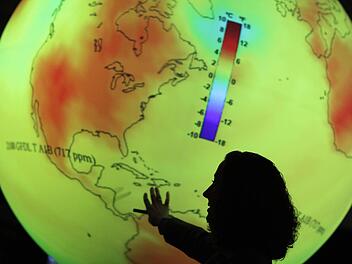 Eine Frau erklärt beim Weltklimagipfel die voraussichtliche Erwärmung der Erde in den kommenden Jahren. Foto: dpa