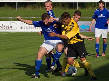 Kasendorfs Florian Luft (blaues Trikot) verliert den Ball an die Frohnlacher Jannik Schmidt (vorne) und Marcel Schöpf (rechts). Hinten SSV-Kapitän Thomas Ellner. Foto: Heinrich Weiß
