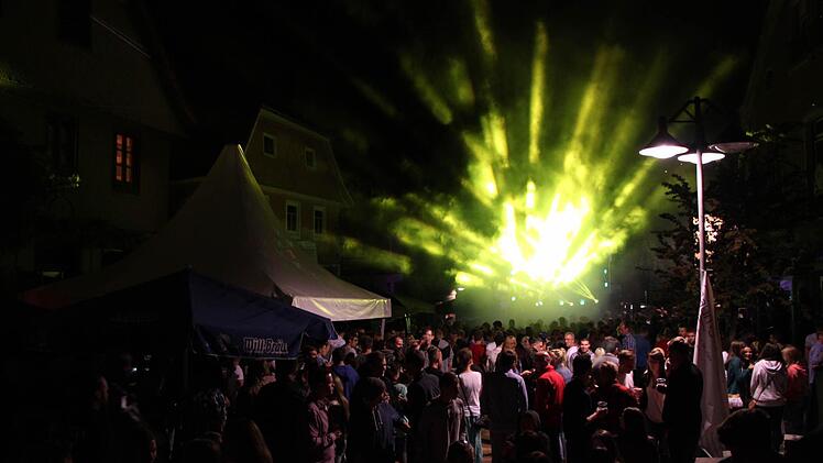 Stadtfest Bad Brückenau 2015: Vor der Jugendbühne in der Altstadt drängen sich die Leute, während eine Laser-Show den Nachthimmel mit bunten Farben beleuchtet. Foto: Friedemann Müller