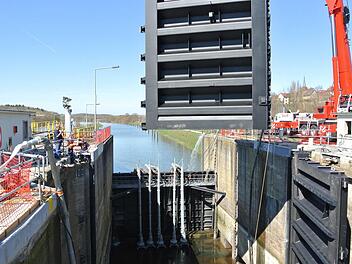 Schauspiel vor der Kirche Ottendorfs: Das rechte Schleusentor ist schon montiert, das linke schwebt gerade ein. Kinderspiel! Wenn alles fertig ist, dürfen die 38 Millionen Liter Mainwasser wieder rein. Fotos: Brigitte Krause