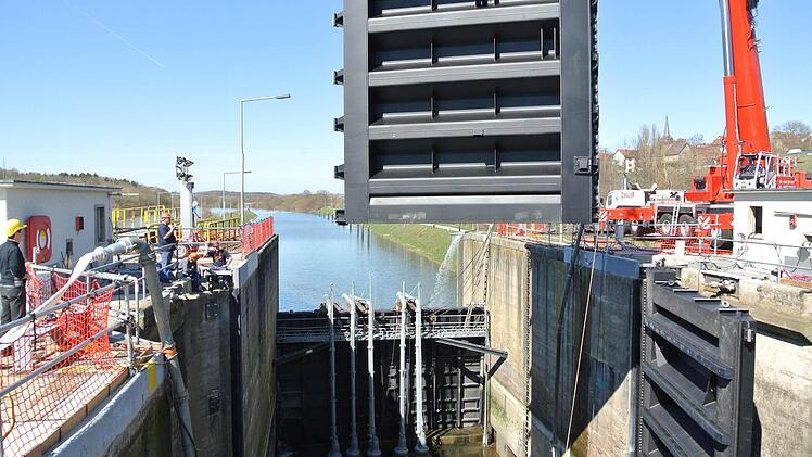 Schauspiel vor der Kirche Ottendorfs: Das rechte Schleusentor ist schon montiert, das linke schwebt gerade ein. Kinderspiel! Wenn alles fertig ist, dürfen die 38 Millionen Liter Mainwasser wieder rein. Fotos: Brigitte Krause