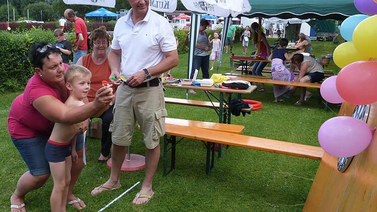 Mama muss mithelfen, damit Sohnemann einen Luftballon trifft. Foto: Werner Rei&szlig;aus