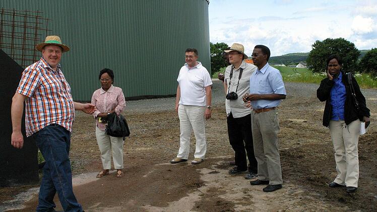 Was Albert Sebald und Gerhard Rößner, die Geschäftsführer der Sankt Johannes Energie GmbH (von links), über die Biogasanlage vor den Toren Seßlachs erklären, wird von Dekanatsmissionspfarrer Andreas Neeb (Bildmitte) für Dekan Malaki Joel Pallangyo (3. von links), Mariam James Mshana, Chrisanta Moris Minja und Sarikioeli Kisali Sarakyikya (von rechts) übersetzt.