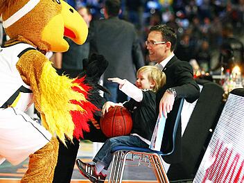 Auf den Knien von Papa Chris freut sich Elias Fleming &uuml;ber den Besuch des Maskottchens der deutschen Nationalmannschaft. Foto: sportpress