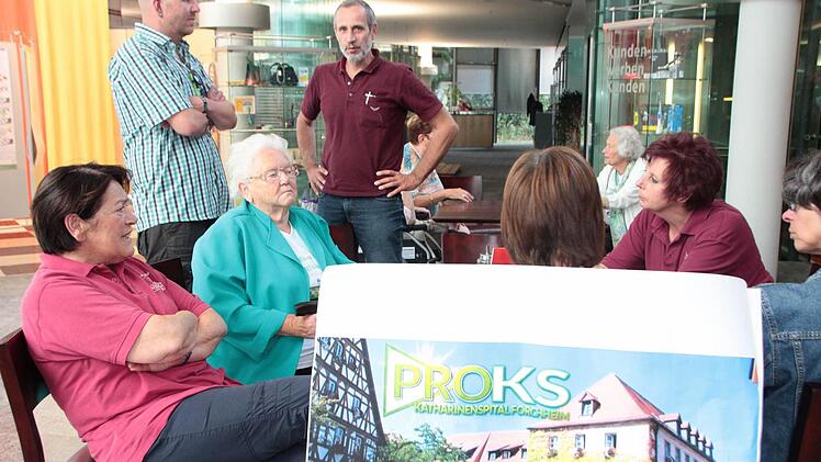 Angestellte des Katharinenspitals, Bewohner und Angehörige warten im Foyer der Sparkasse genervt auf den um über eine Stunde verschobenen Beginn der öffentlichen Stadtratssitzung. Foto: Foto: Andreas Oswald