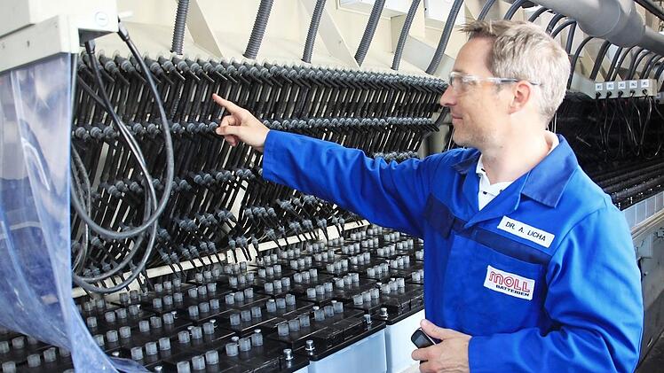 Produktionsleiter Andreas Licha erklärt, wie die neue Ladestation arbeitet. Aus diesen Schläuchen fließt die Säure in die Batterien.