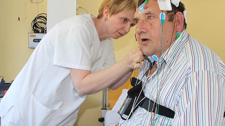 Mit geübten Handgriffen verkabelt Carmen Thierauf, medizinische Fachangestellte im Schlaflabor, Reinhard Beetz für die Analyse seines Schlafes. Mit Hilfe der Elektroden werden verschiedene Körperfunktionen erfasst. Aus den aufgezeichneten Daten wird ein so genanntes Polysomnogramm erstellt, das detaillierte Informationen über die Schlafqualität liefert.