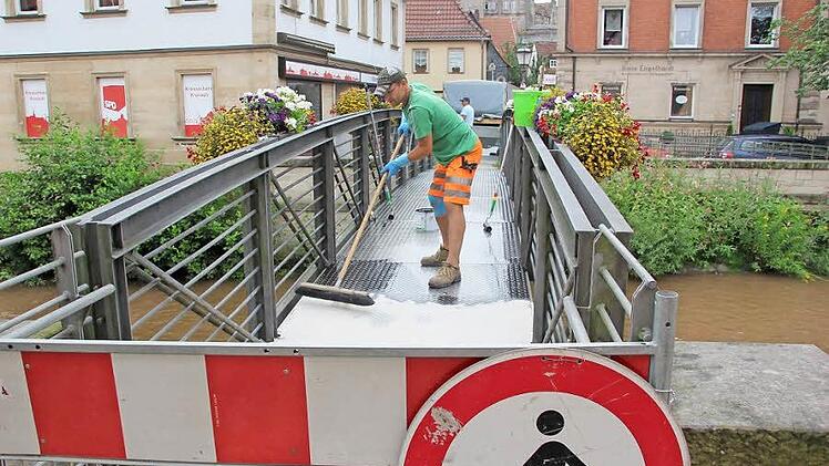 Ein Bauhofmitarbeiter verteilt am Freitag den Quarzsand auf dem Eisernen Steg. Fotos: Andreas Schmitt