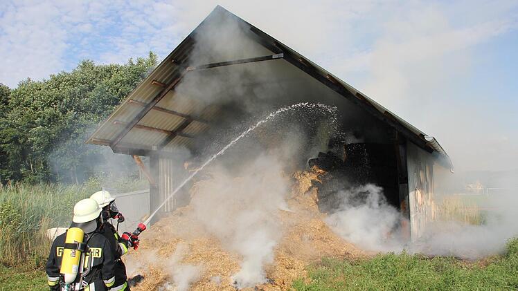 Die Feuerwehr im Einsatz: Ständig drang Qualm aus der brennenden Scheune. Das gelagerte Stroh fing immer wieder Feuer.  Klaus Schmitt