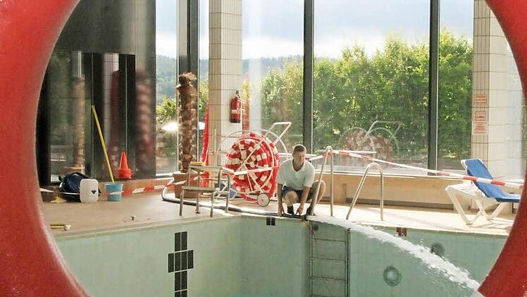 In zwei Wochen muss alles sauber und repariert sein: Schwimmmeister Denis Latyschev legt einen Schlauch aus, damit das große Becken wieder mit Wasser gefüllt und auf die Temperatur von 28 Grad gebracht werden kann. Fotos: Thomas Heuchling