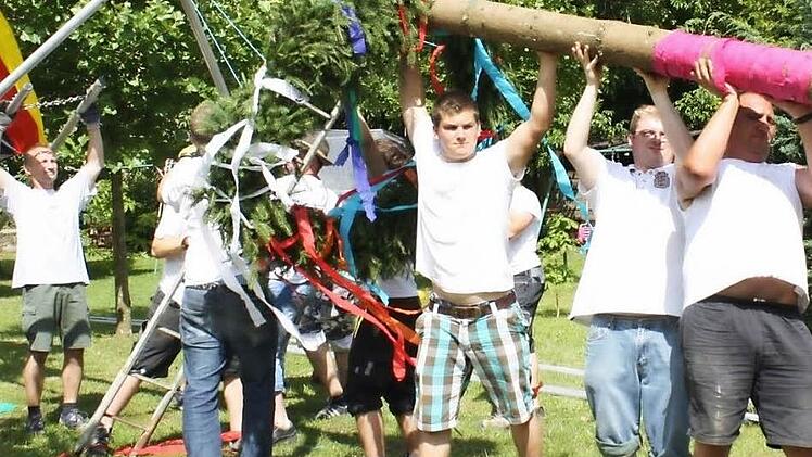 Mit vereinten Kräften stemmten die Mitglieder von Hüttla und Ponderosa den 27 Meter langen Kerwasbaum in die Höhe.  Foto: Sonja Werner