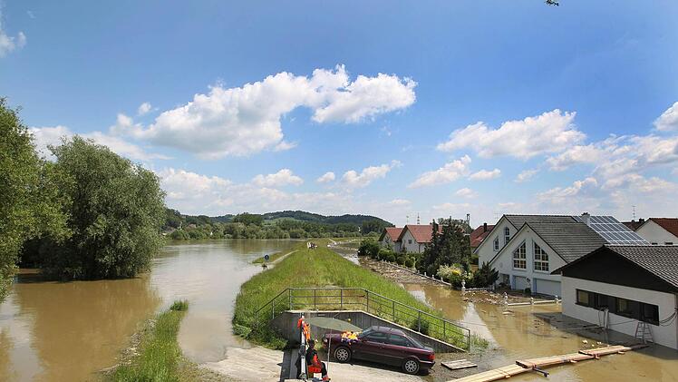Ein Helfer sitzt in Deggendorf vor einer Hochwassersperre, die das Wasser der Donau zurückhalten soll. Foto: Karl-Josef Hildenbrand/dpa