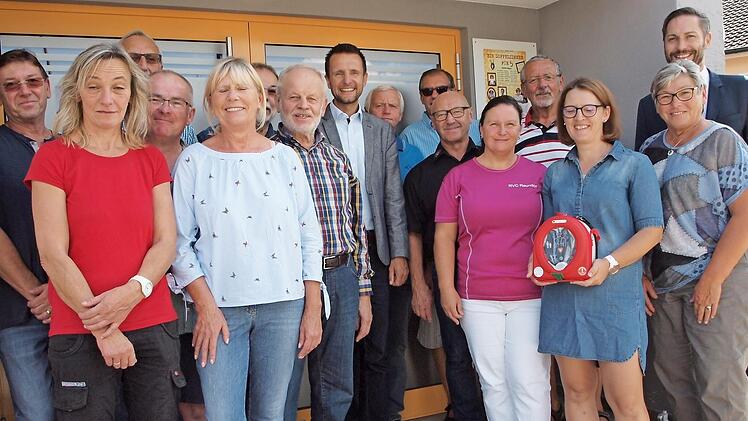 Siegfried Kerner (Vierter von rechts) als Sprecher der Vereine, Michaela Vogel (mit Defibrillator) als Initiatorin, Bürgermeister Andreas Hügerich sowie die Vertreter der Reundorfer Vereine bedankten sich beim Vorstand der Raiffeisen-Volksbank Bad Staffelstein, Christoph Bäumel (rechts), für die Spende eines Defibrillators für die Maintalhalle im Wert von rund 2500 Euro.  Foto: Alfred Thieret